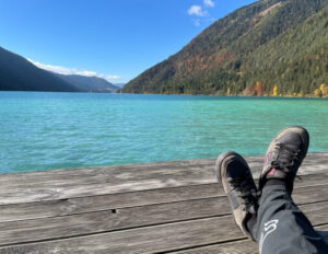 Landschaft mit See und Berge und Sportschuhe